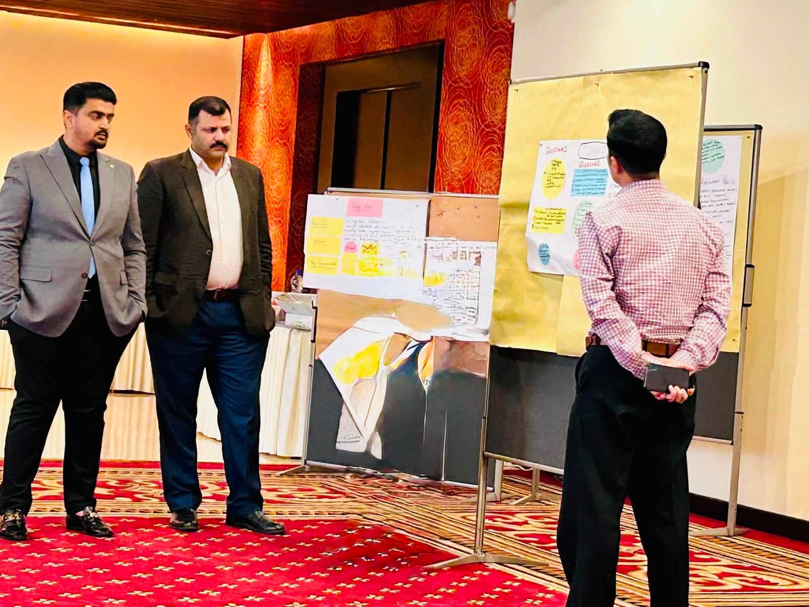 Participants reviewing group outputs on flip charts during the EU-supported capacity-building training at Ramada Hotel, Islamabad